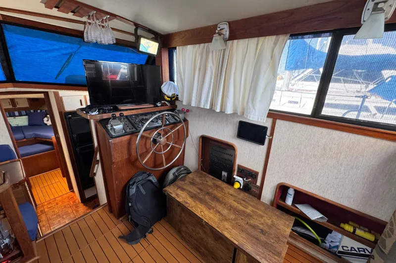 1985 Carver 3607 Aft Cabin Motor Yacht interior with helm, TV, and seating area.