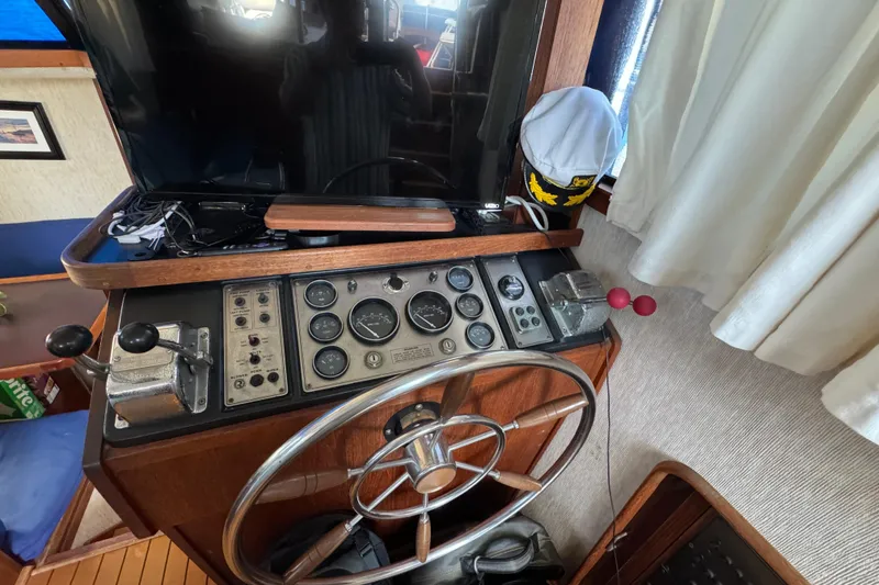 1985 Carver 3607 Aft Cabin Motor Yacht helm with steering wheel and control panel.