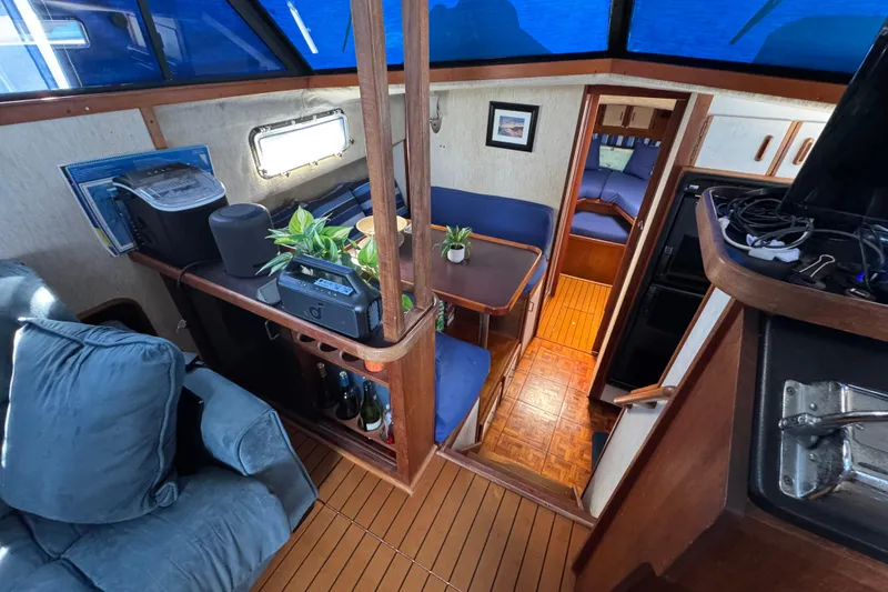 Interior of 1985 Carver 3607 Aft Cabin Motor Yacht with cozy seating and wooden accents.