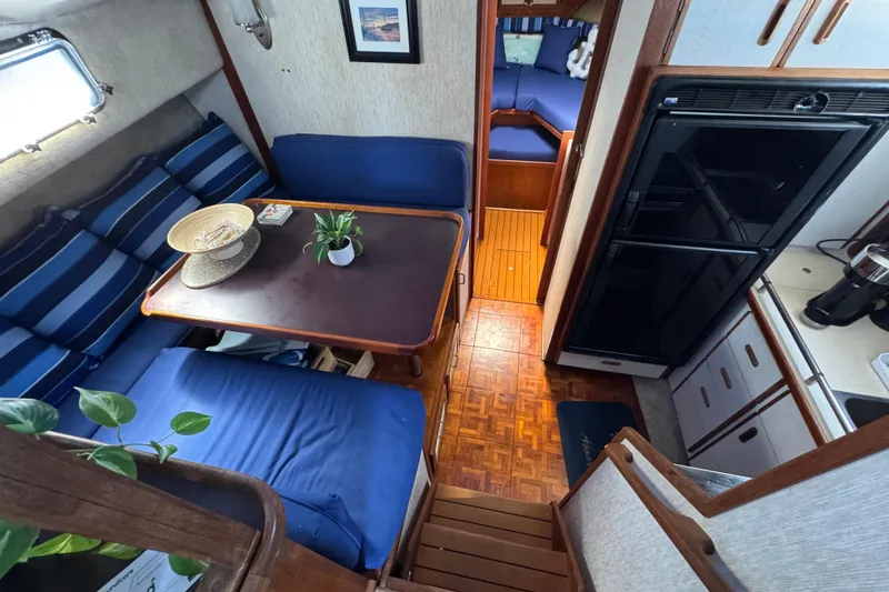 Interior of 1985 Carver 3607 Aft Cabin Motor Yacht with cozy seating and kitchenette.