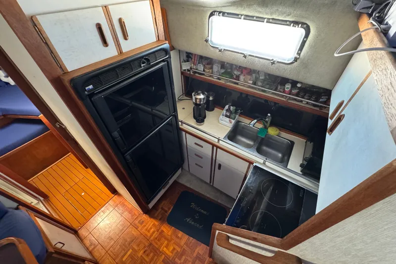 1985 Carver 3607 Aft Cabin Motor Yacht kitchen with stove, sink, and refrigerator.