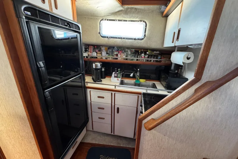 Compact kitchen in 1985 Carver 3607 Aft Cabin Motor Yacht with appliances and storage.