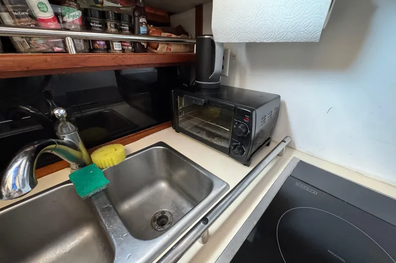 Compact kitchen area in 1985 Carver 3607 Aft Cabin Motor Yacht with sink and toaster oven.