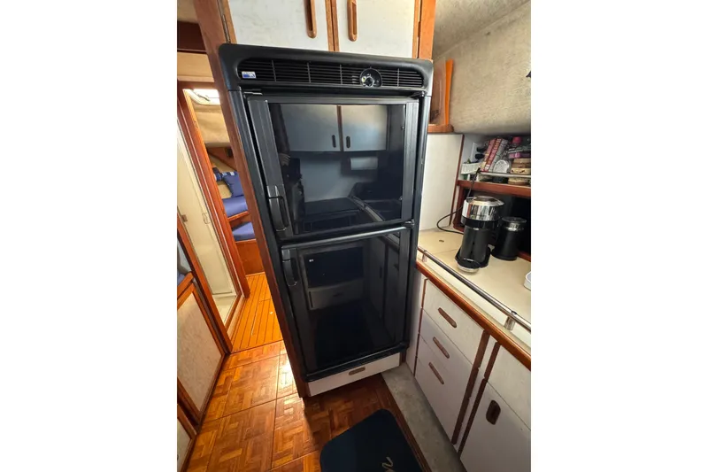 1985 Carver 3607 Aft Cabin Motor Yacht interior kitchen with refrigerator and coffee maker.