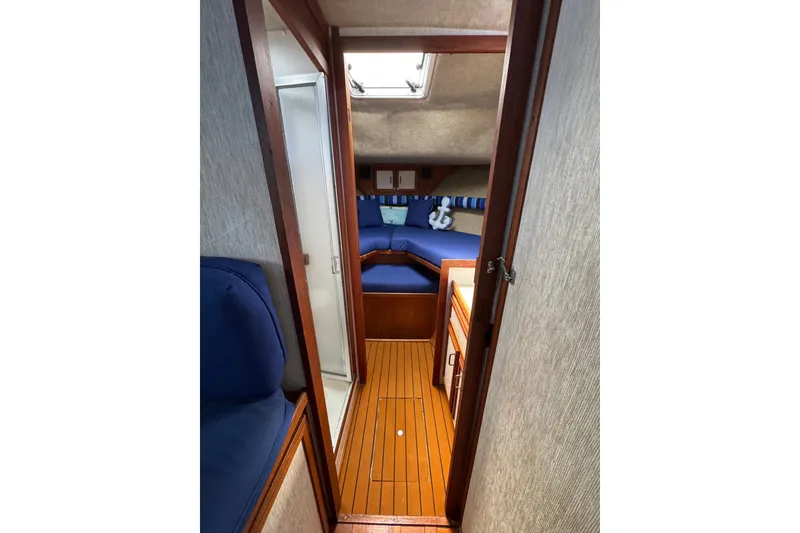 1985 Carver 3607 Aft Cabin Motor Yacht interior with wood flooring and blue seating.