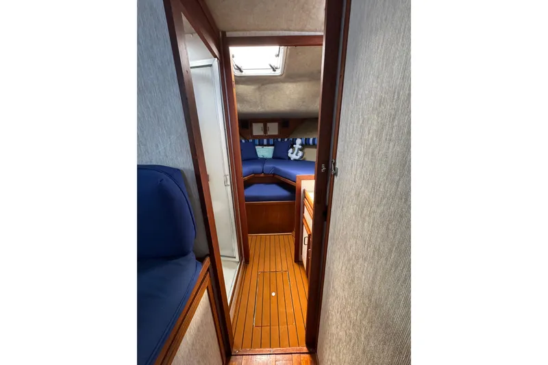 1985 Carver 3607 Aft Cabin Motor Yacht interior with wood flooring and blue seating.