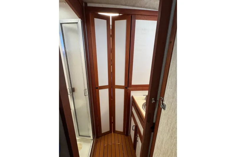 1985 Carver 3607 Aft Cabin Motor Yacht bathroom with shower and wooden accents.