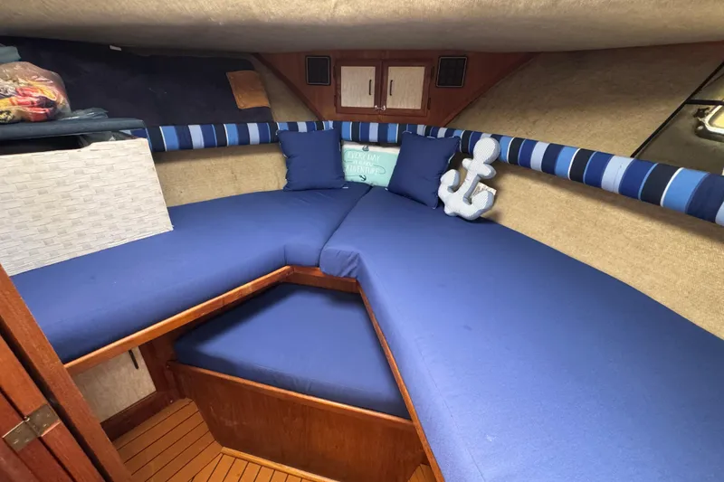 1985 Carver 3607 Aft Cabin Motor Yacht interior with blue cushions and nautical decor.