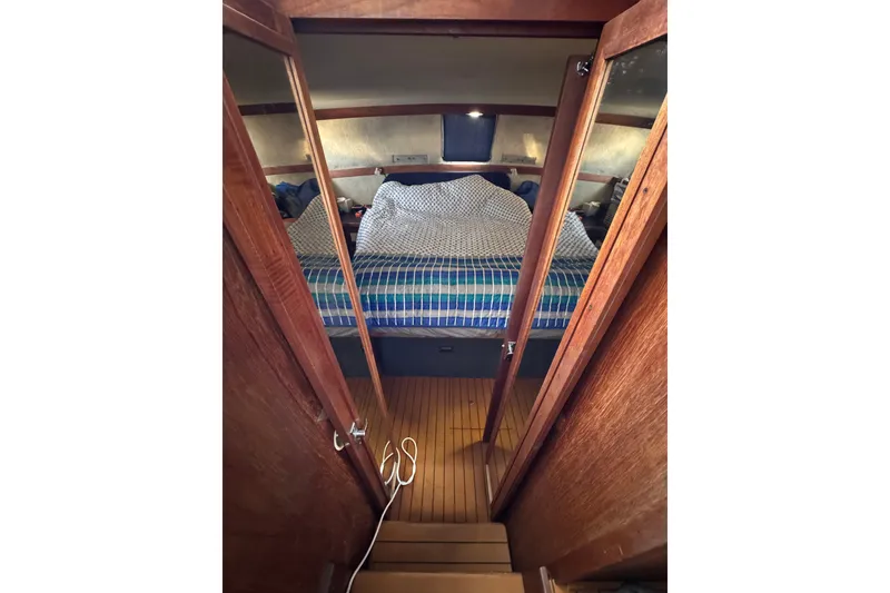 1985 Carver 3607 Aft Cabin Motor Yacht interior with cozy bed and wooden finish.