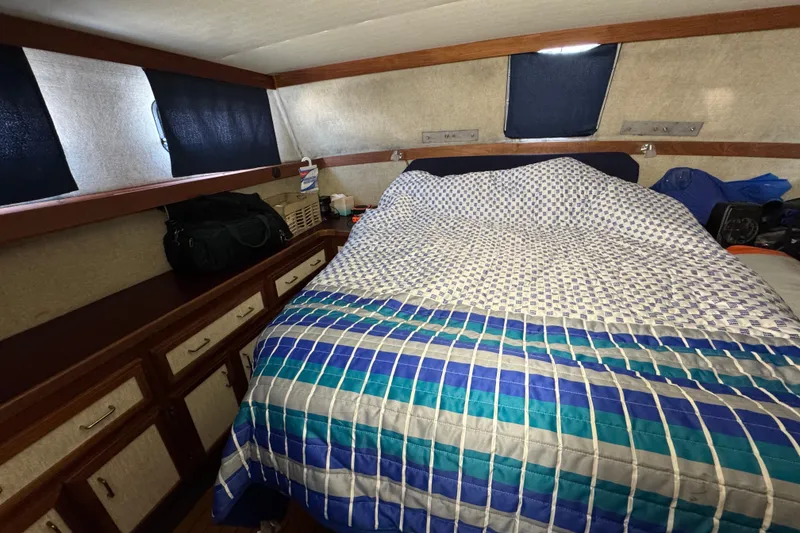 1985 Carver 3607 Aft Cabin Motor Yacht interior with bed and storage cabinets.