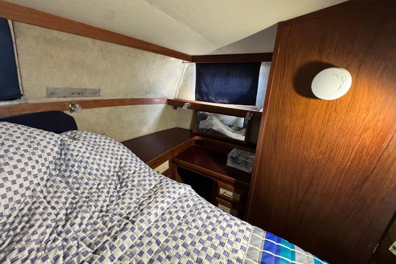 Interior cabin of 1985 Carver 3607 Aft Cabin Motor Yacht with bed and wooden furnishings.