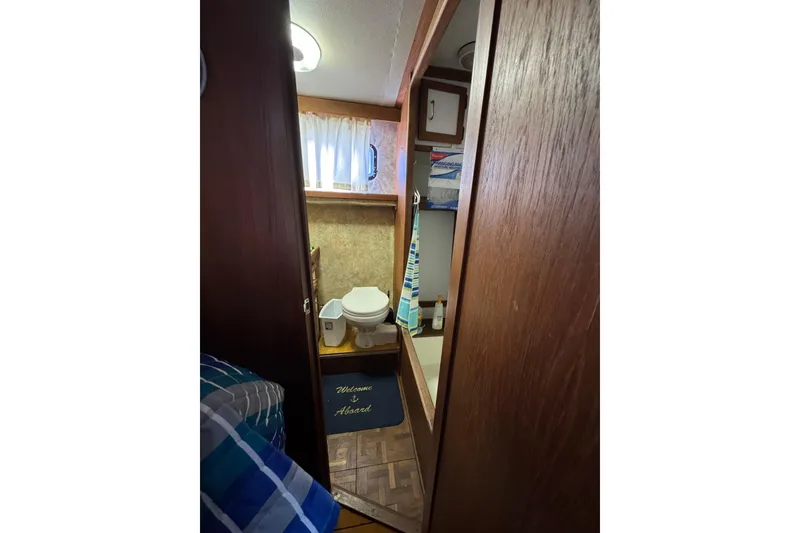 1985 Carver 3607 Aft Cabin Motor Yacht bathroom with toilet and storage.