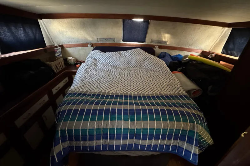 Cozy cabin interior of 1985 Carver 3607 Aft Cabin Motor Yacht with bed and storage.