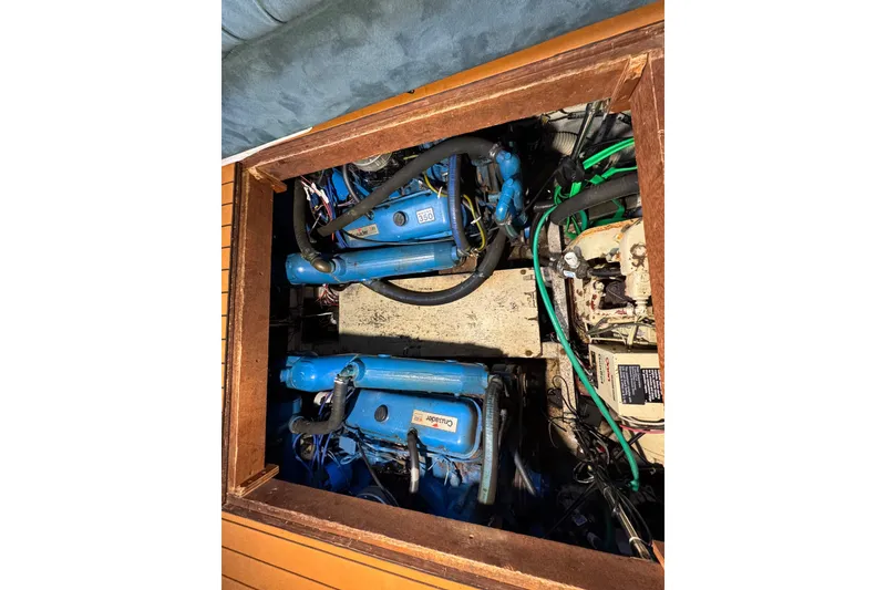 Engine compartment of 1985 Carver 3607 Aft Cabin Motor Yacht, featuring blue marine engines.