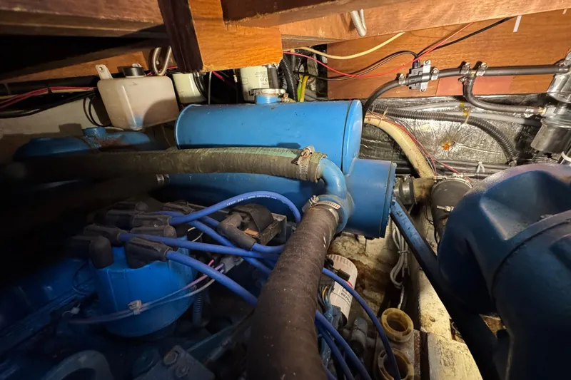 Engine compartment of 1985 Carver 3607 Aft Cabin Motor Yacht with blue components and wiring.