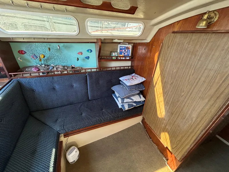 Interior of a 1981 Catalina 30 sailboat with cozy seating and nautical decor.