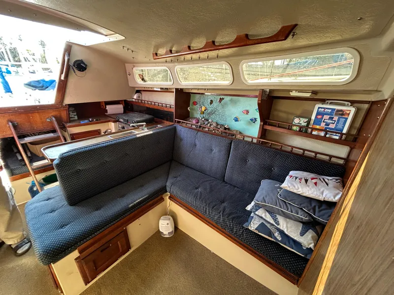 Interior of 1981 Catalina 30 sailboat with cozy seating and nautical decor.