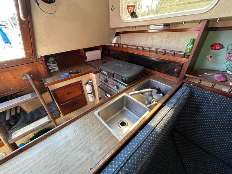 Interior of a 1981 Catalina 30 sailboat galley with sink, stove, and storage.