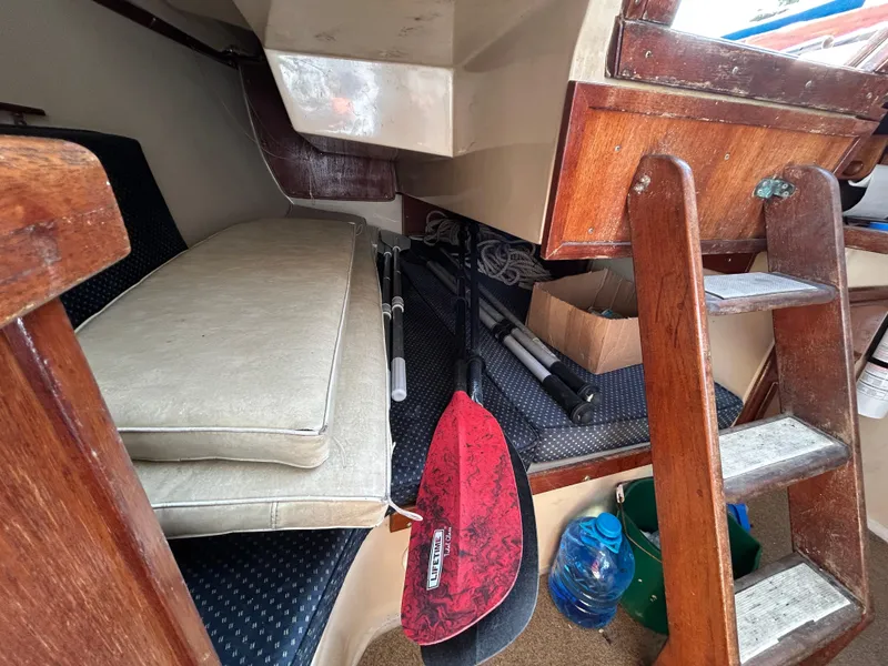 Interior of 1981 Catalina 30 sailboat with cushions, paddles, and storage items.