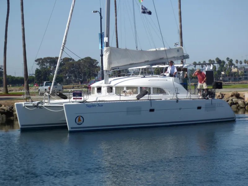 2015 Lagoon 380 catamaran docked in a marina with people on deck.