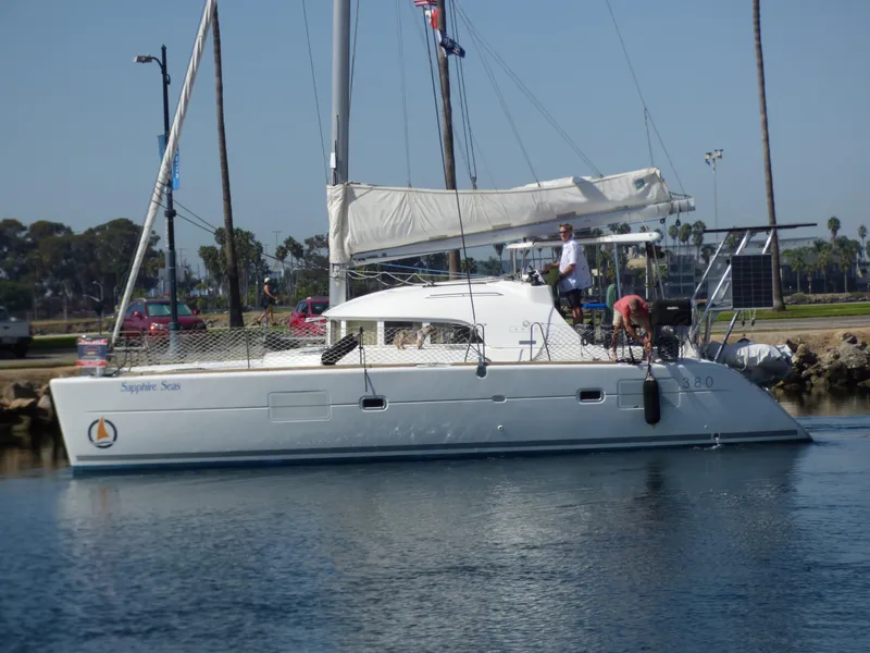 2015 Lagoon 380 catamaran docked, featuring sails and crew on deck.