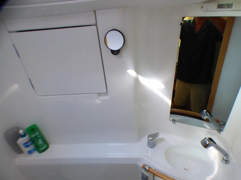 Bathroom interior of 2015 Lagoon 380 catamaran with sink, mirror, and toiletries.