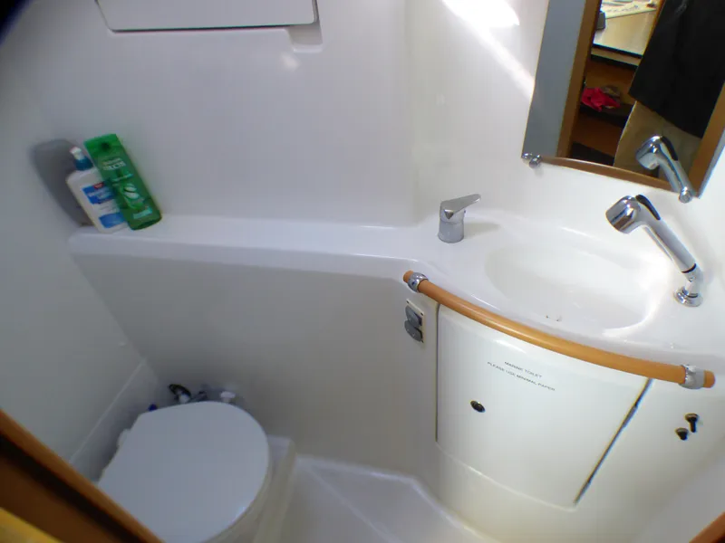 Bathroom interior of 2015 Lagoon 380 catamaran with sink, toilet, and toiletries.