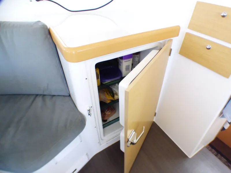 Open cabinet with food storage inside a 2015 Lagoon 380 catamaran interior.