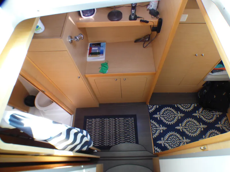Interior view of 2015 Lagoon 380 catamaran cabin with wooden cabinetry and patterned rug.