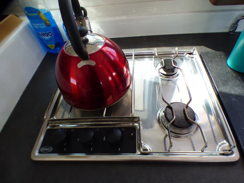 Red kettle on a stainless steel stove in a Lagoon 380, 2015 model.