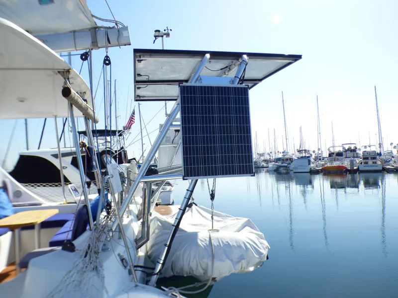 2015 Lagoon 380 catamaran with solar panels docked in a marina.