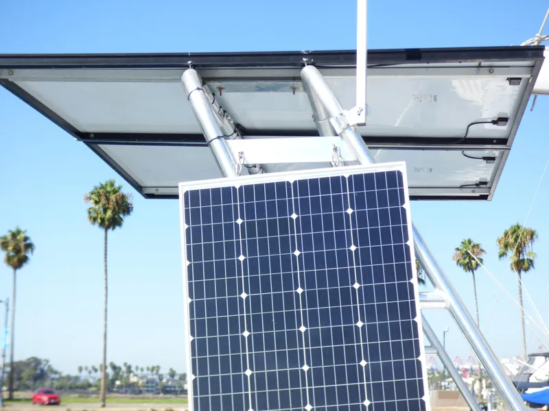 Solar panels on a 2015 Lagoon 380 catamaran with palm trees in the background.