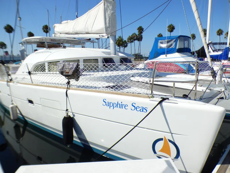 2015 Lagoon 380 catamaran "Sapphire Seas" docked in a marina with palm trees.