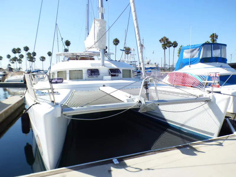 2015 Lagoon 380 catamaran docked at marina with palm trees in background.