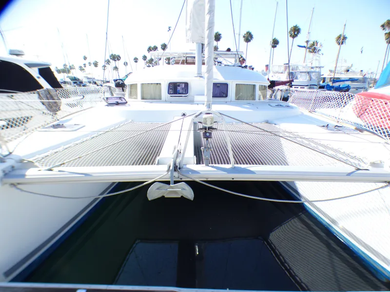 2015 Lagoon 380 catamaran docked at marina with palm trees in background.