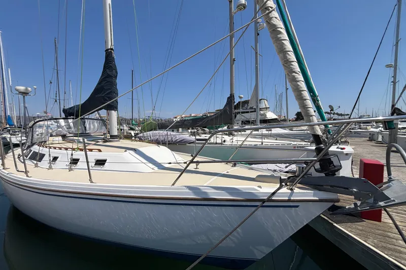 1987 Catalina 34 sailboat docked at marina under clear blue sky.