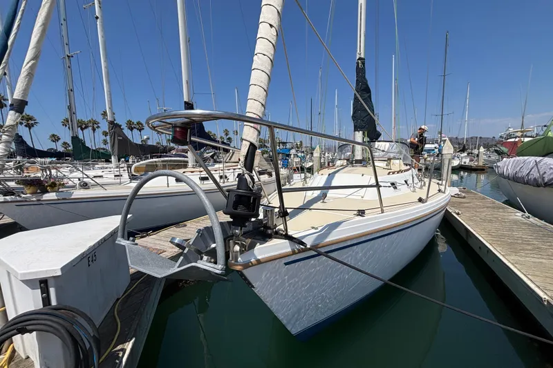 1987 Catalina 34 sailboat docked at marina under clear blue sky.