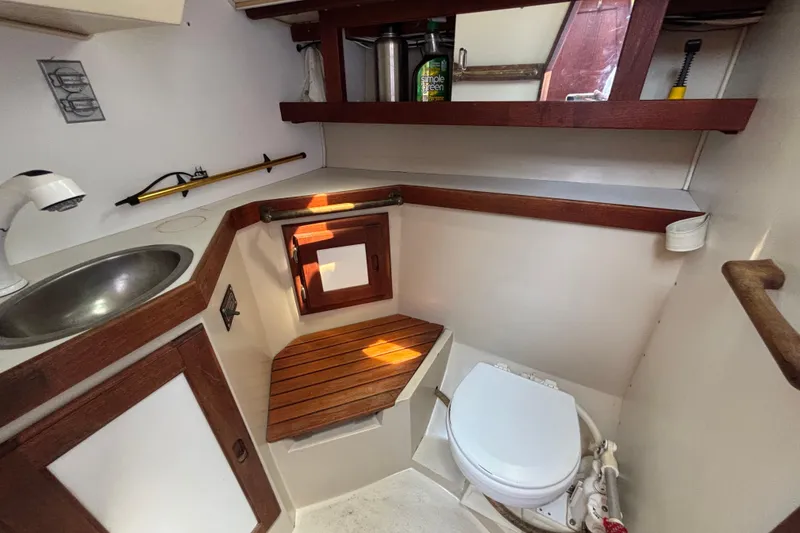 1987 Catalina 34 boat bathroom with sink, toilet, and wooden accents.