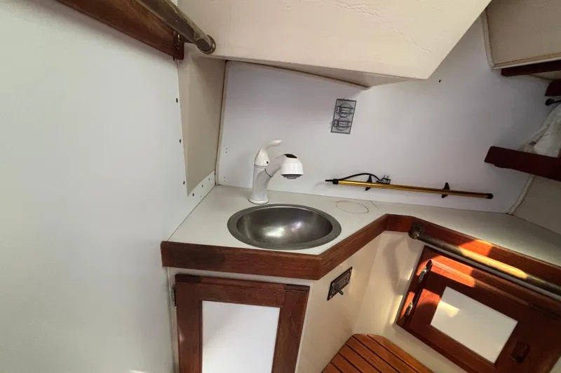 1987 Catalina 34 yacht interior with compact sink and wooden cabinetry.