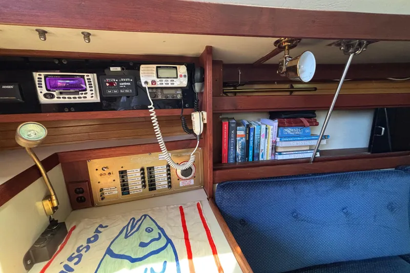 1987 Catalina 34 yacht interior with navigation equipment, books, and cozy seating area.