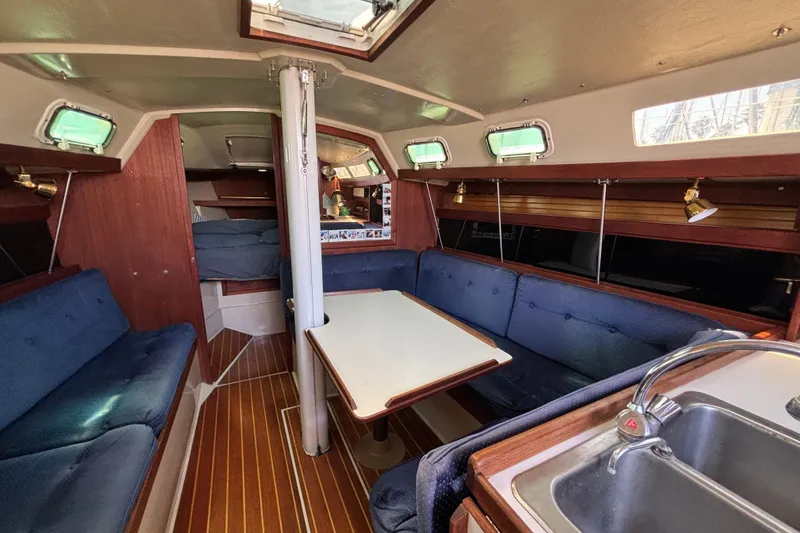 Interior of a 1987 Catalina 34 sailboat with cozy seating and wooden finishes.