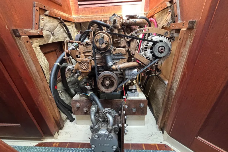 Engine compartment of a 1987 Catalina 34 sailboat, showcasing mechanical components and wiring.