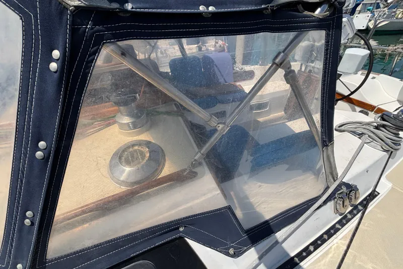 1987 Catalina 34 sailboat cockpit with clear protective cover and visible winch.