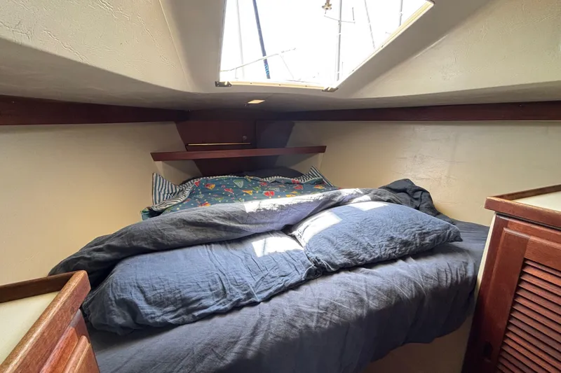 Cozy cabin interior of 1987 Catalina 34 sailboat with skylight and bedding.