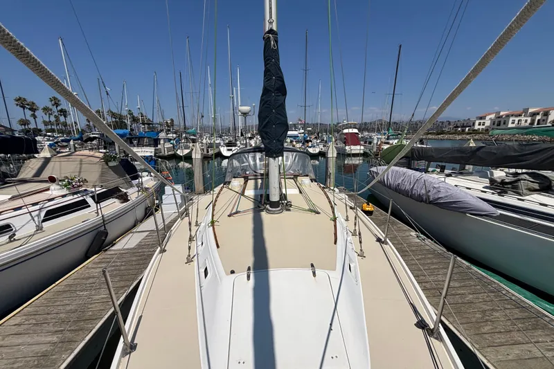 1987 Catalina 34 sailboat docked in a marina, surrounded by other boats.