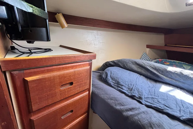 Cozy cabin interior of 1987 Catalina 34 sailboat with wooden drawers and bed.