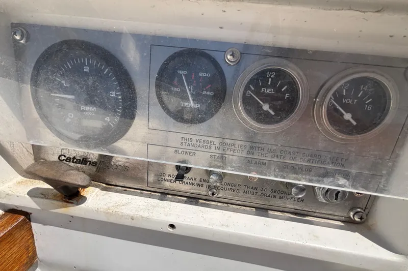 Dashboard of a 1987 Catalina 34 sailboat with gauges and safety instructions.