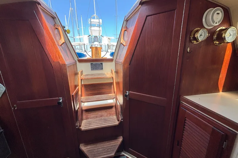 Interior view of 1987 Catalina 34 sailboat with wooden steps and nautical instruments.