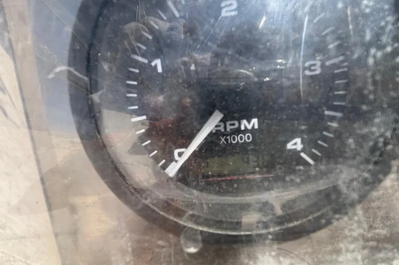 Close-up of a Catalina 34 tachometer, showing RPM readings, slightly obscured by reflections.