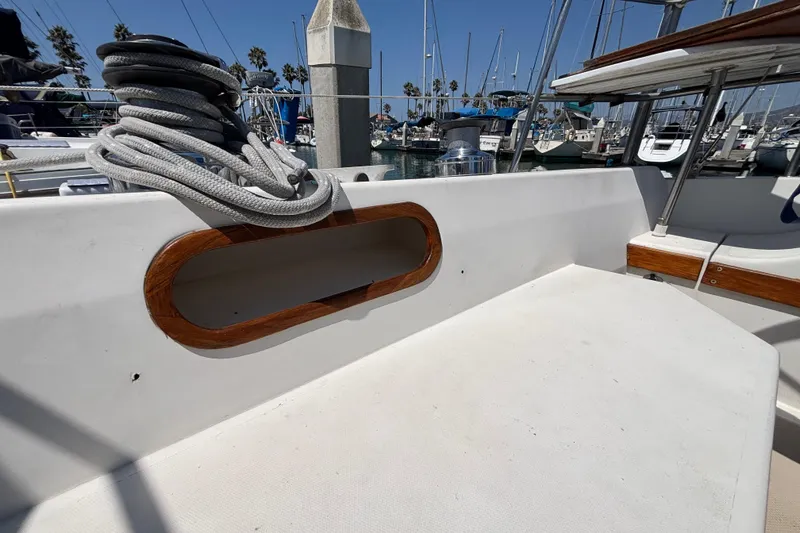 1987 Catalina 34 sailboat deck with coiled rope and marina background.